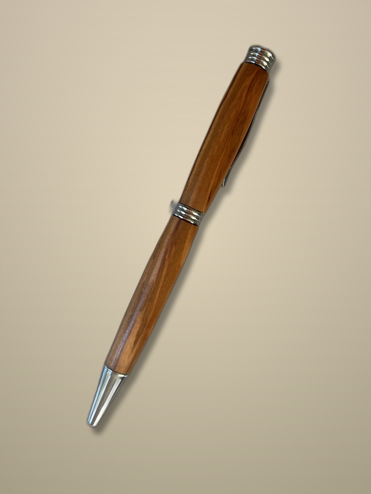 Finished olive wood pen styled on a warm studio backdrop