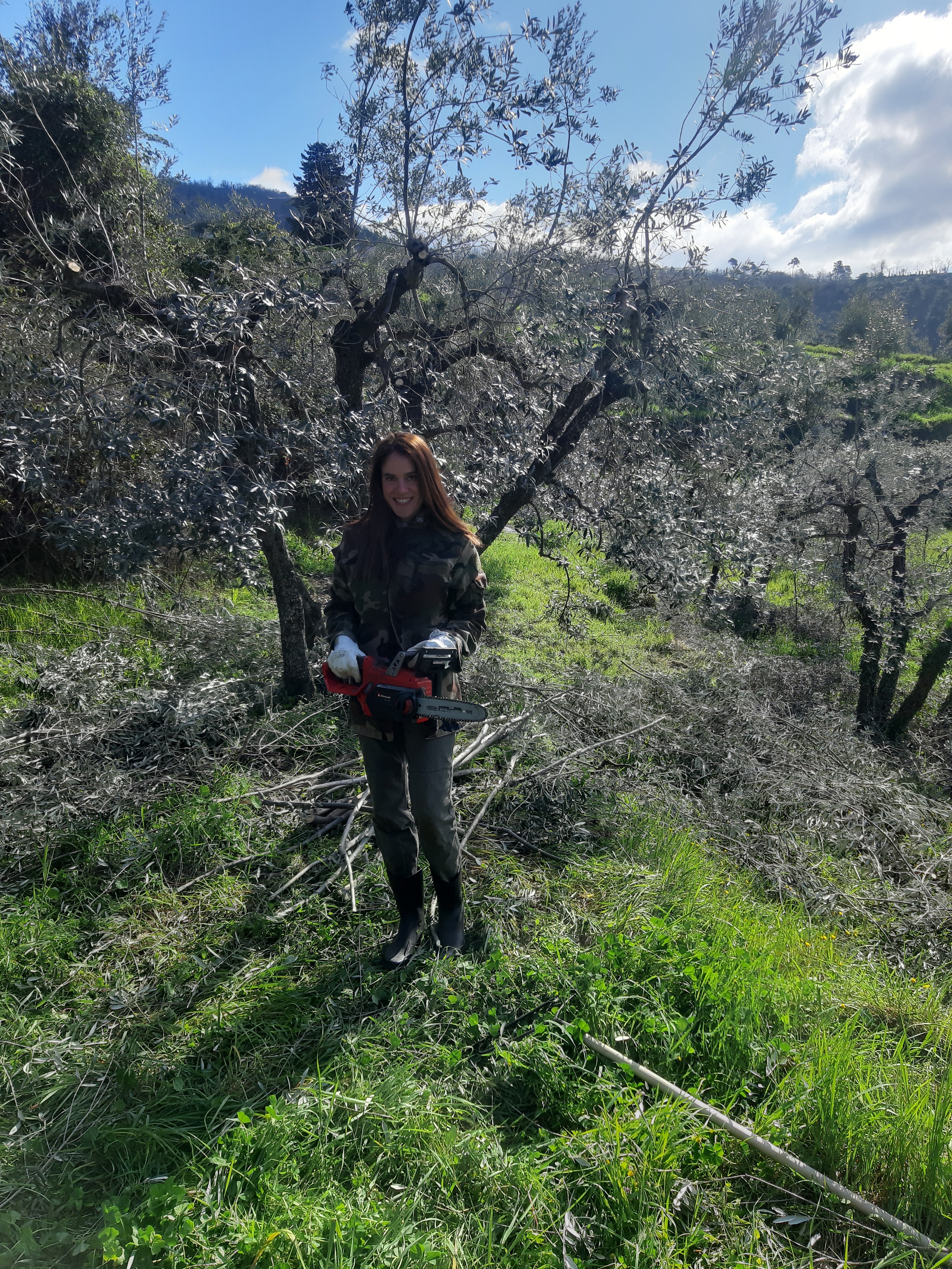 Lavinia working in the olive grove with a chainsaw